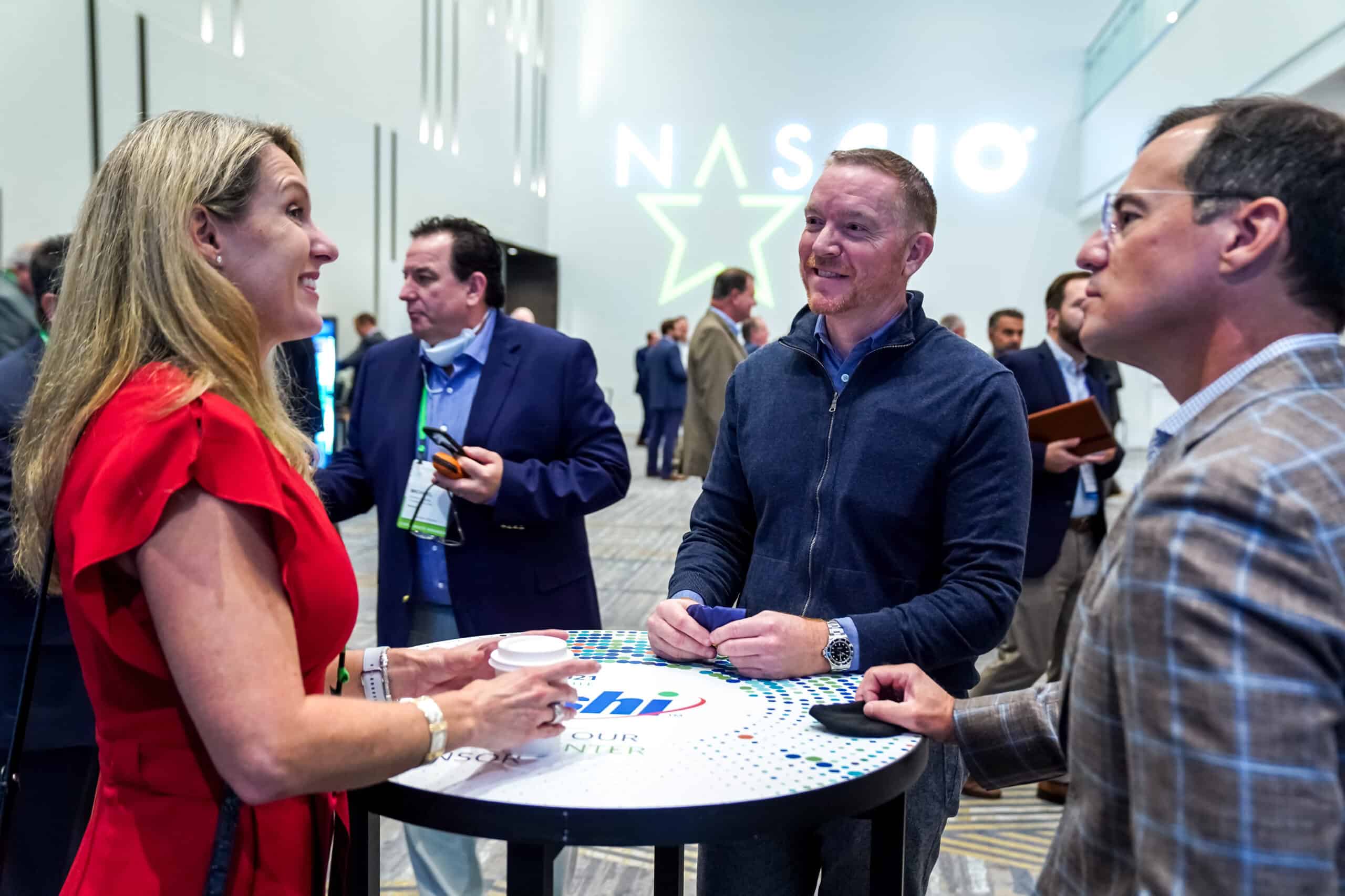 Attendees at table with sponsor logos