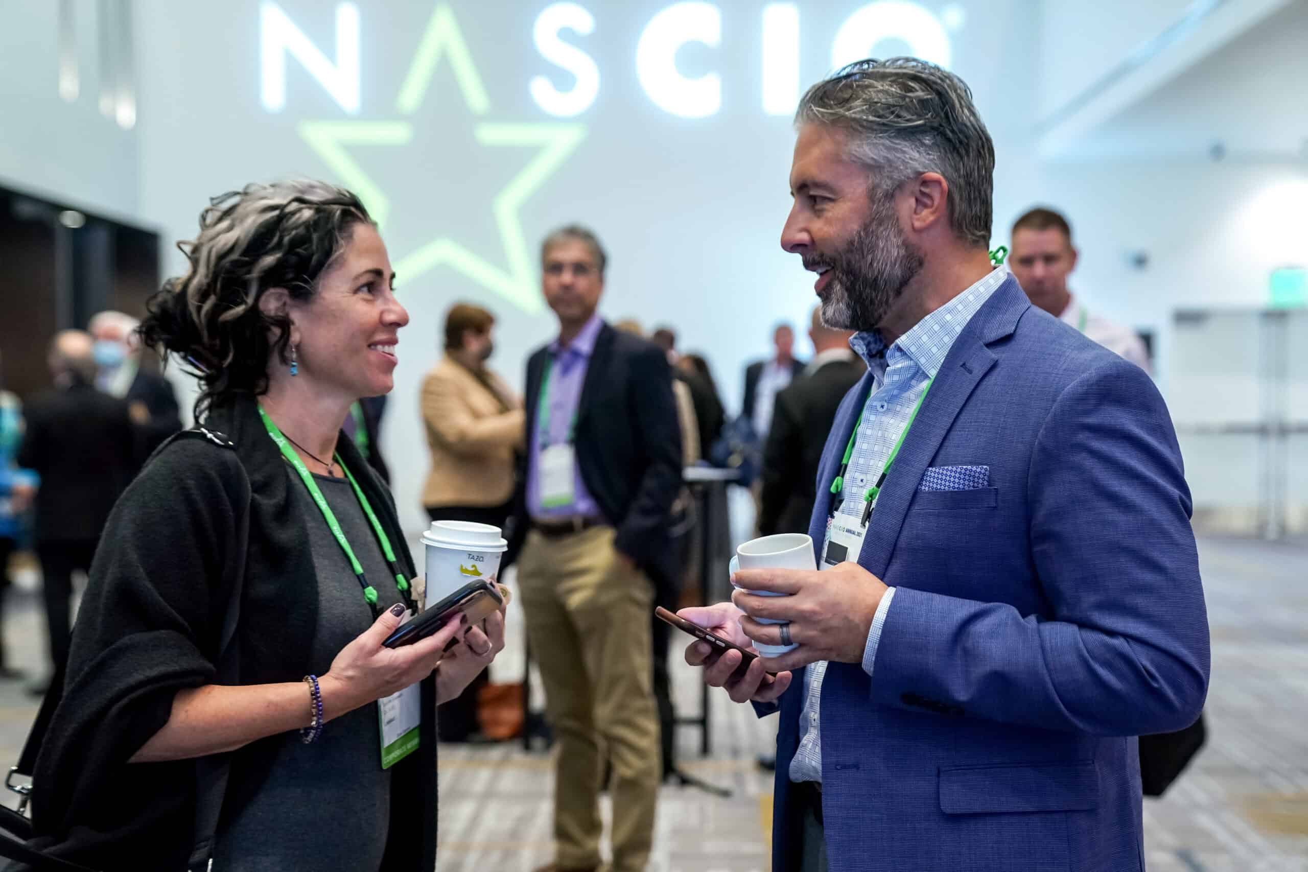 Attendees talking with NASCIO logo in background