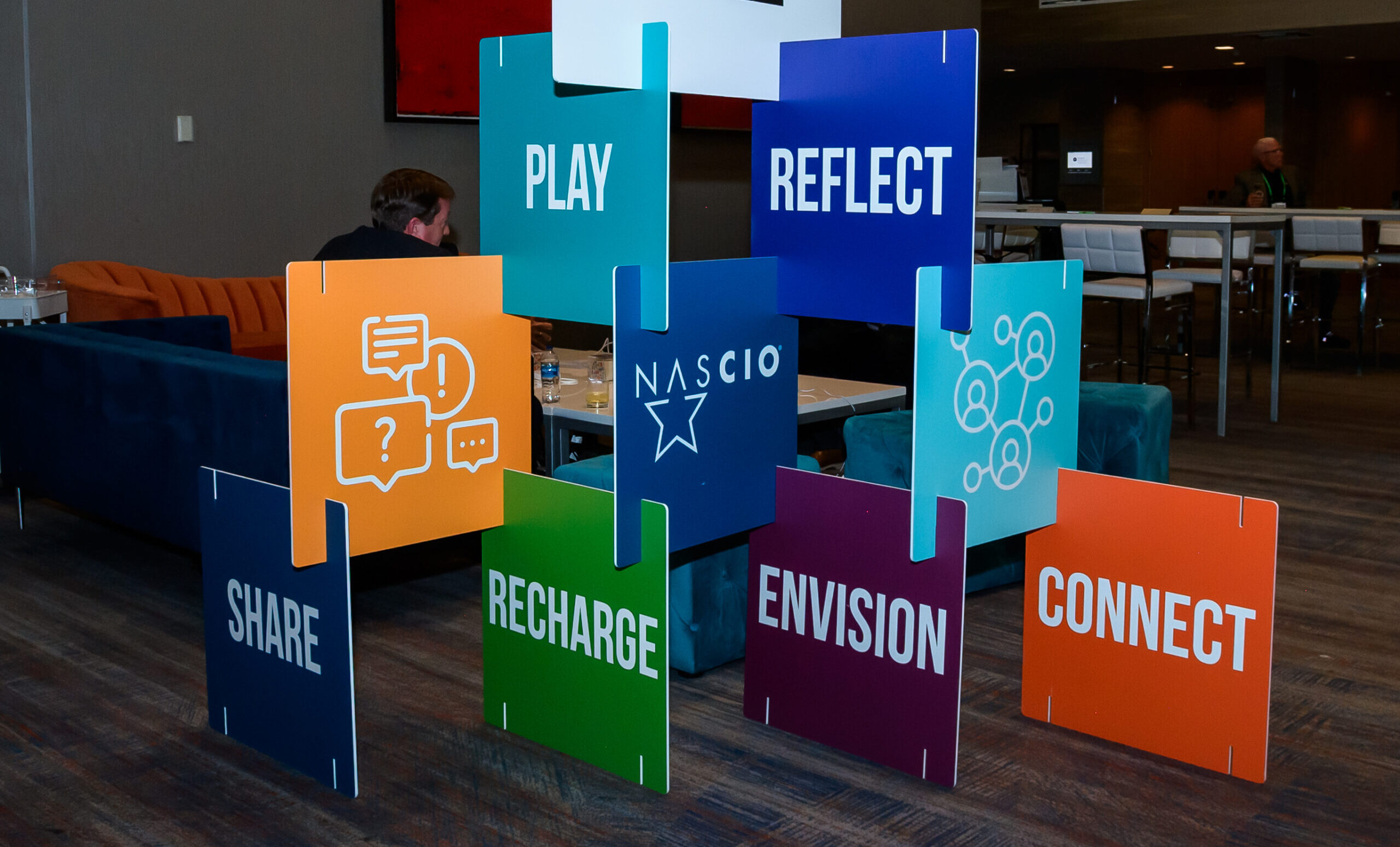 sign installation at an event with pieces reading Share, Recharge, Enision, Connect, Play and Reflect
